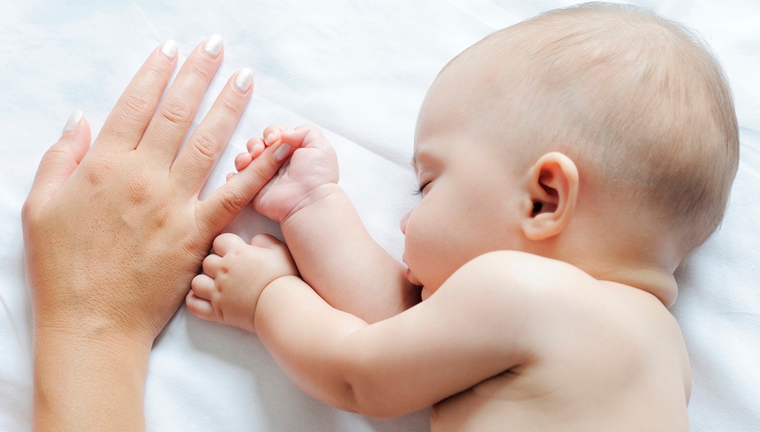 bebe durmiendo en colchón para minicuna